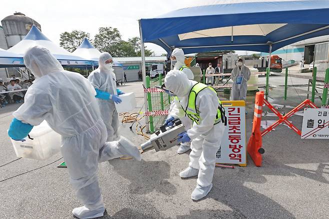 지난해 8월 전북 임실군 임실축협에서 열린 ‘2023 아프리카돼지열병(ASF) 가상방역훈련’에서 동물위생시험소 가축방역관이 혈액과 개인 소독을 하고 있다. /뉴스1