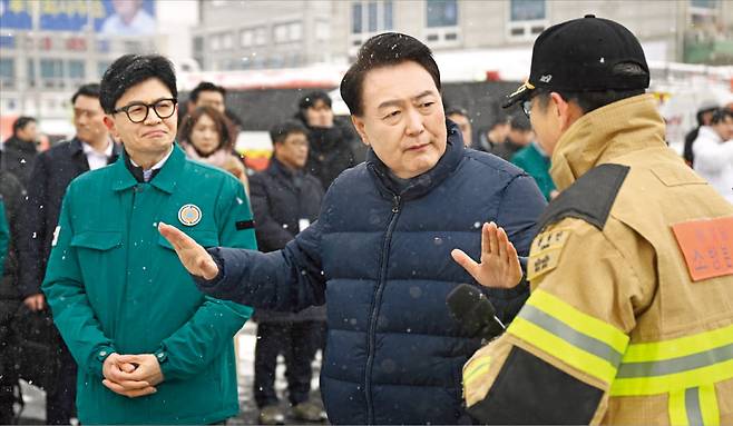 윤석열 대통령과 한동훈 국민의힘 비상대책위원장이 23일 충남 서천특화시장 화재 현장을 방문했다. 전날 밤 발생한 화재로 점포 227개가 불에 탄 현장을 점검하고 상인 지원 등 대책을 마련했다. 윤 대통령과 한 위원장이 권혁민 충남 소방본부장으로부터 피해 상황을 보고받고 얘기하고 있다. 대통령실 제공