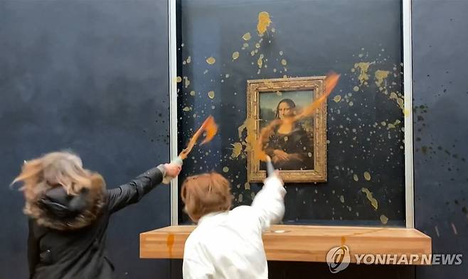 모나리자에 수프 끼얹는 시위대 (파리 AFP=연합뉴스) 28일(현지시간) 파리 루브르박물관에서 여성 2명이 모나리자를 향해 수프를 뿌리고 있다. 2024.1.28