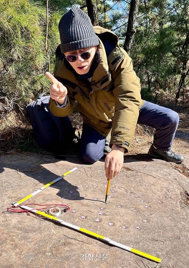생태학자인 김종원 전 교수가 지난 23일 대구 달성군 죽곡산 정상 부근에서 둥근 윷판형 암각화가 뚜렷하게 새겨진 퇴적암에 대해 설명하고 있다. 백경열 기자