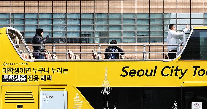 외국인 관광객들이 '노랑풍선' 시티투어 버스에서 서울 거리 사진을 찍고 있습니다. 쌀쌀해도 서울을 좀 더 자세히 보고 싶어하는 마음이 느껴지네요. 이충우 기자