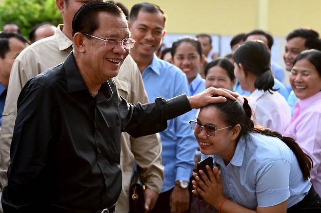 지난달 25일(현지시간) 상원의원 선거 후 지방의원과 인사하는 훈 센(왼쪽) 전 캄보디아 총리.(사진=AFP)