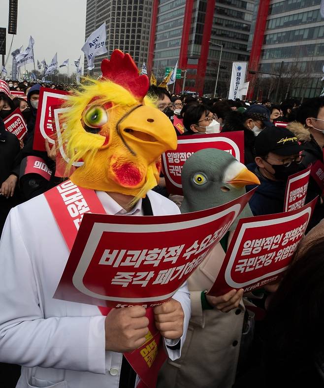 3일 서울 영등포구 여의대로에서 열린 '의대정원 증원 및 필수의료 패키지 저지를 위한 전국 의사 총궐기 대회'에서 의사 가운을 입은 참석자가 닭과 비둘기의 탈을 쓰고 손팻말을 들고 있다. 사진=뉴스1