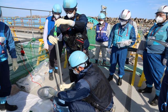 후쿠시마 제1원자력발전소 오염수 2차 방류를 앞둔 지난해 10월 3일 후쿠시마현 오쿠마에서 도쿄전력 직원들이 샘플 채취를 하고 있다. 오쿠마=EPA 연합뉴스
