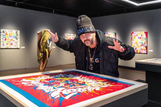 시릴 콩고가 에르메스와 협업한 스카프 앞에서 포즈를 취하고 있다(사진=뮤지엄 웨이브).