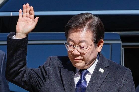 이재명 더불어민주당 대표가 지난 18일 오후 서울 서초구 중앙지방법원에서 열린 위증교사 혐의 관련 공판에 출석하며 지지자들을 향해 손들고 있다. 뉴스1