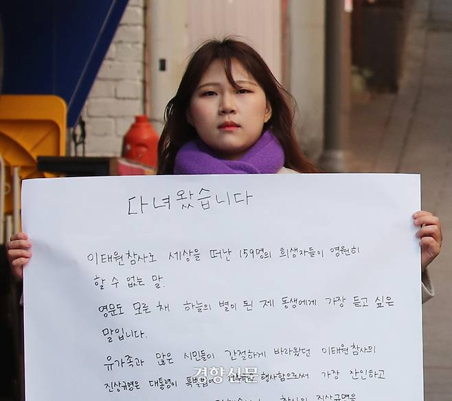 10.29이태원참사 희생자 고 유연주 씨의 언니 유정 씨가 21일 서울 이태원역 1번 출구 앞 이태원참사 추모의 벽에서 2030세대에게 호소하는 대자보를 작성한 후 사진을 찍고 있다. 2024. 3. 21. 김창길기자