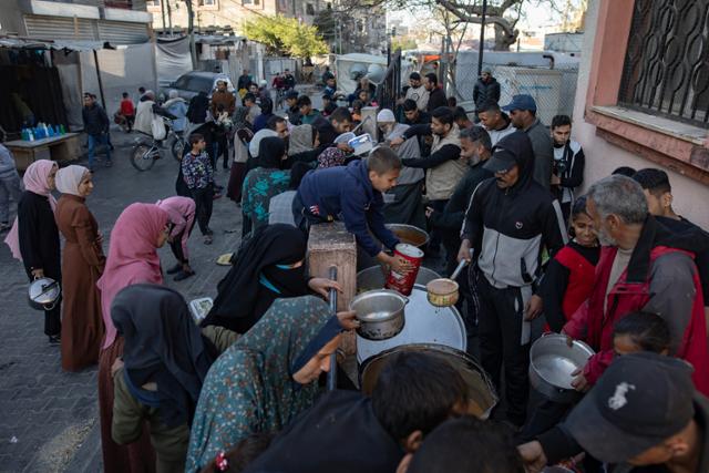 팔레스타인 피란민들이 23일 가자지구 최남단 도시 라파에서 자선단체의 식량 배급을 받기 위해 몰려 있다. 라파=EPA 연합뉴스