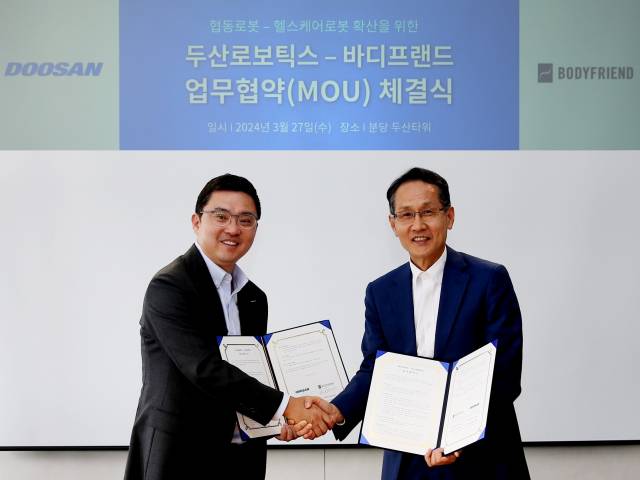 류정훈(왼쪽) 두산로보틱스 대표와 지성규 바디프랜드 대표가 27일 경기도 분당 두산타워에서 열린 ‘헬스케어로봇과 협동로봇 확산을 위한 업무협약’ 체결식에서 악수하고 있다. 사진제공=바디프랜드