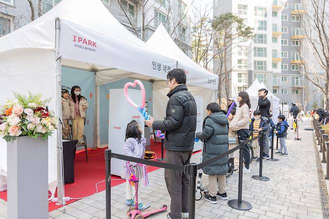 지난 9일 서울 강동구 고덕 센트럴 아이파크에서 열린 아이파크 홈커밍데이 행사에서 입주민들이 인생네컷 서비스를 이용하고 있다. HDC현대산업개발 제공