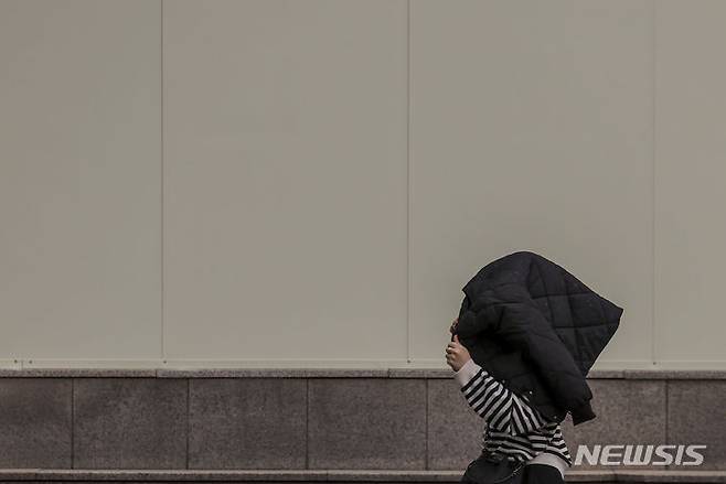 [서울=뉴시스] 정병혁 기자 = 전국 대부분의 지역에 황사와 미세먼지의 영향으로 대기질이 나쁜 가운데 29일 서울  중구 시청역 인근에서 옷으로 머리를 가린 시민이 비를 피해 이동하고 있다. 2024.03.29. jhope@newsis.com