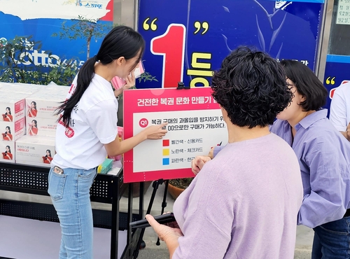 지난해 경상북도 포항 지역 복권판매점에서 진행된 ‘건전문화 캠페인’에서 한 시민이 복권 관련 퀴즈 이벤트에 참여하고 있다. |동행복권