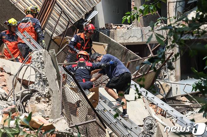 타이베이에서 한 남성이 구조대원들의 부축을 받으며 조난 현장에서 걸어나오고 있다. 2024.04.03 ⓒ AFP=뉴스1 ⓒ News1 정지윤