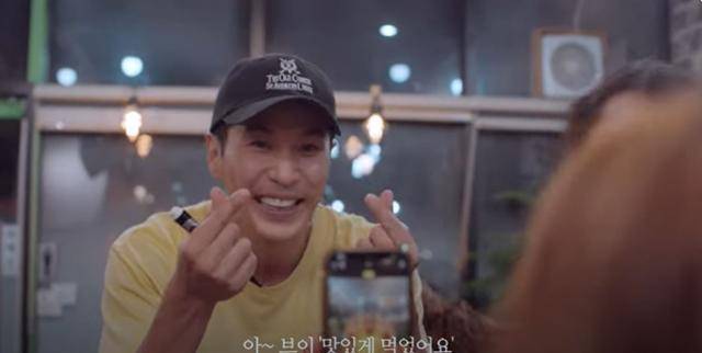 배우 김지석이 그가 직접 기획한 유튜브 드라마 '나는 김지석이다'에서 식당에서 손가락으로 하트 모양을 하며 사진을 찍고 있다. '배우 김지석으로 살아남기' 위해 그는 드라마를 직접 기획했다. 김지석 유튜브 영상 캡처