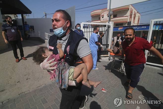 이스라엘 공습으로 다친 아이 이송하는 팔레스타인인 (가자지구 신화=연합뉴스) 지난해 10월 23일(현지시간) 가자지구 라파에서 팔레스타인인이 이스라엘 공습으로 다친 아이를 안고 이송하고 있다. 2023.10.24 ddy04002@yna.co.kr