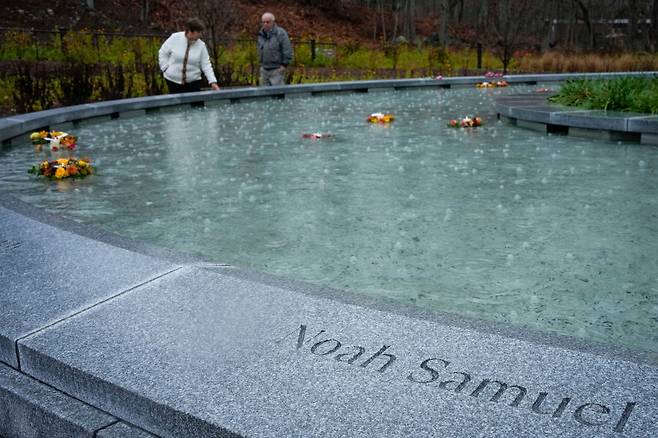 샌디 훅 초등학교 총기 난사 희생자 추모 공원 개장을 하루 앞두고 열린 12일 추모 행사에 참여한 유족들이 희생자의 이름이 새겨진 추모비를 돌아보고있다./AP 연합뉴스