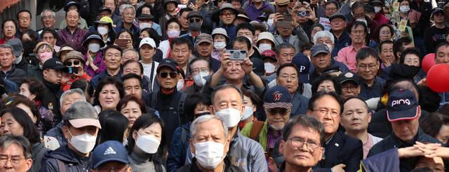 4·10 총선 사전투표를 하루 앞둔 4일 서울 시내에서 시민들이 한 후보의 유세를 보고 있다. 연합뉴스