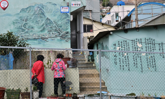 마산의 쇠락한 반월시장 담에 그려진 옛 마산의 모습을 담은 벽화와 유행가 가사.