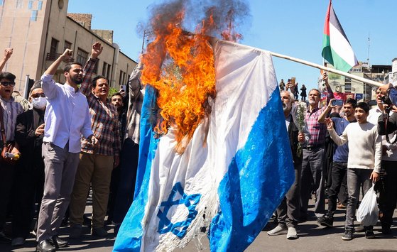 지난 5일(현지시간) 이란 테헤란에서 열린 이스라엘의 시리아 주재 이란 영사관 공습으로 사망한 이란 장교 7명에 대한 장례식에서 시위대가 이스라엘 국기를 불태우고 있다. AFP=연합뉴스