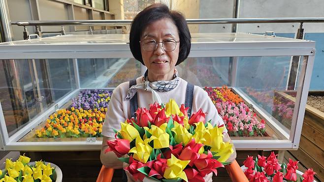 지난 9일 서울 은평구 치매안심센터 2층 화단 앞에서 자신이 만든 종이 꽃을 들고 환하게 웃고 있는 김운자씨 모습. /강지은 기자