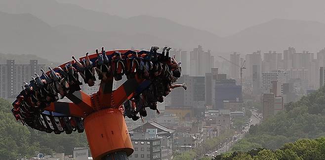 17일 대구 달서구 이월드에서 시민들이 미세먼지로 뿌연 대구 도심 속에서 놀이기구를 타고 있다. 연합뉴스