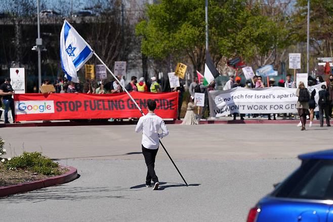 16일(현지시간) 미국 캘리포니아 서니베일에 있는 구글 클라우드 사무실에서 이스라엘 국기를 든 반대 시위대가 시위 현장 인근 주차장으로 걸어 들어가고 있다. (사진=로이터)