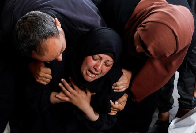 한 팔레스타인 여성이 16일 가자지구 남부 라파에서 이스라엘군 공습으로 사망한 가족 시신을 보며 오열하고 있다. 라파=로이터 연합뉴스