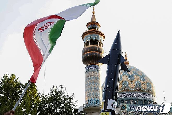 15일(현지시간) 이란 테헤란의 팔레스타인 광장에 사람들이 이란 국기와 미사일 모형을 들고 자축하고 있다. 2024.04.15 ⓒ AFP=뉴스1 ⓒ News1 정지윤 기자