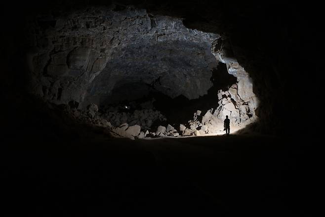 사우디아라비아 움 지르산 용암 동굴에서 과학자들이 손전등을 들고 내부를 탐사하는 모습. 용암 동굴은 최소 7000년 동안 유목민에게 쉼터를 제공한 것으로 밝혀졌다./Palaeodeserts project