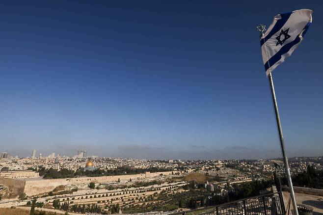 19일(현지 시각) 예루살렘의 알 아크사 모스크 단지와 스카이라인이 내려다보이는 올리브 산에 이스라엘 국기가 펄럭이고 있다. / AFP 연합뉴스