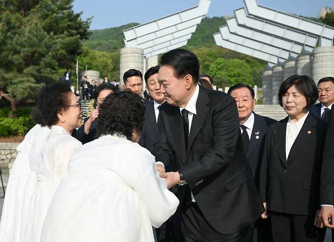  윤석열 대통령이 19일 서울 강북구 국립4·19민주묘지에서 참배를 마친 뒤 희생자 유족들과 인사하고 있다.