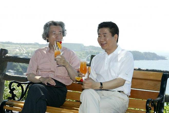 노무현 전 대통령과 고이즈미 전 일본총리가 2004년 7월 22일 오전 제주 신라호텔 뒤편에 위치한 일명 ‘쉬리벤치’에 앉아 음료를 마시고 있다.[노무현사료관]