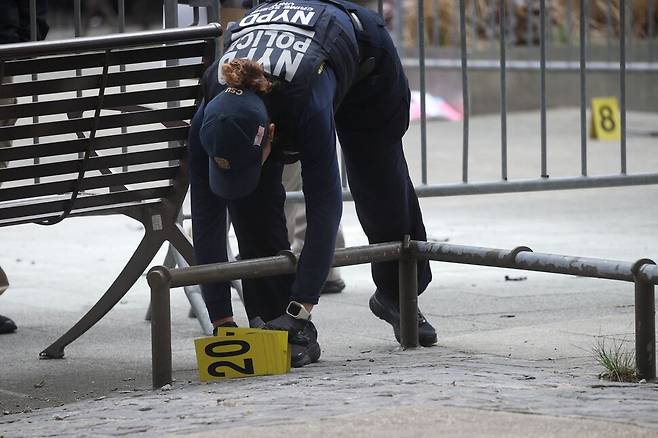 뉴욕 경찰이 19일(현지시간) 오후 뉴욕에서 한 남성이 분신했던 맨해튼 형사법원 외곽 공원 주변에서 증거를 수집하고 있다. 뉴욕/AFP 연합뉴스