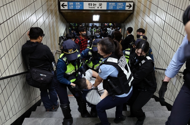 제44회 장애인의 날인 20일 오전 서울 지하철 4호선 한성대입구역에서 열린 장애인단체들의 '다이 인(die-in)' 퍼포먼스에 참가했던 활동가(가운데)가 경찰에 연행되고 있다. 연합뉴스