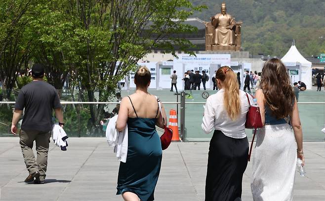 전국이 대체로 맑고 낮 최고 기온이 18∼27도의 날씨를 보인 18일 서울 광화문광장에서 가벼운 옷차림을 한 외국인 관광객들이 걷고 있다. [연합]