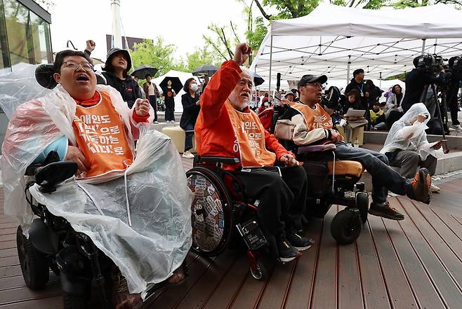 장애인의 날인 20일 오전 서울 종로구 마로니에공원에서 열린 ‘2024년 420장애인차별철폐투쟁 결의대회’에서 박경석 전국장애인차별철폐연대(전장연) 공동대표를 비롯한 참석자들이 구호를 외치고 있다. [연합]