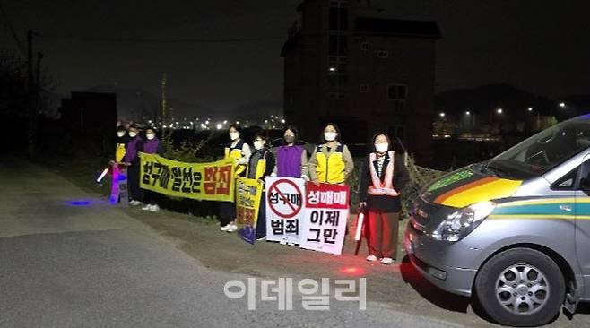 시민들이 성매매집결지 진입로 앞에서 야간 캠페인 ‘올빼미 활동’을 하고 있다.(사진=파주시 제공)