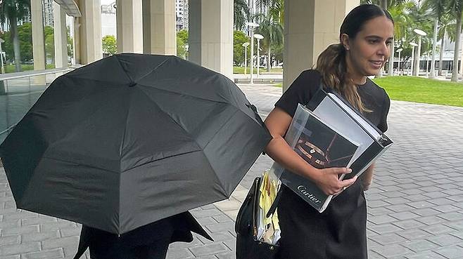 우산 뒤로 얼굴을 감추고 법원에 출두한 핸드백 디지이너 낸시 곤살레스 (사진=AP, 연합뉴스)