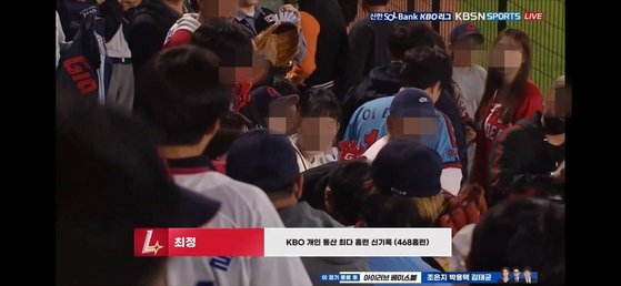 24일 부산 사직구장을 찾은 관중들이 최정의 468호 홈런볼을 잡은 야구팬 강성구씨에게 축하를 보내고 있다. 사진 티빙 캡처