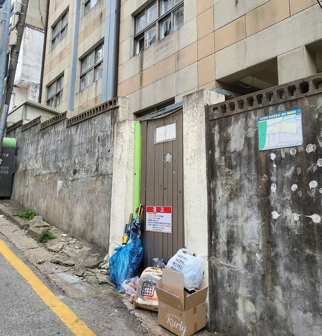 폐교한 은혜초 옆문 앞에 쓰레기들이 버려져 있다. 박혜원 기자