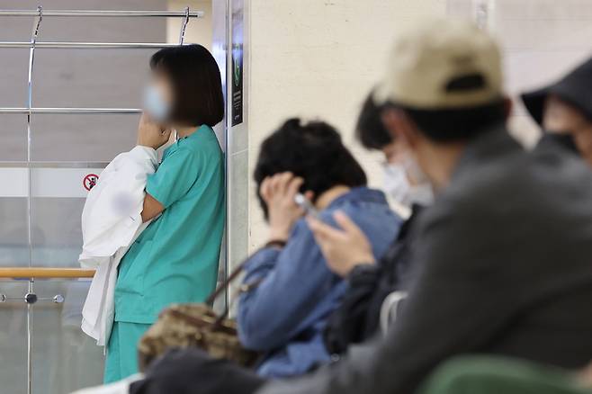 의대 교수들이 사직서를 제출한 지 한 달이 다 되어가며 사직이 현실화할 수 있다는 우려가 제기되는 가운데 24일 서울 시내 한 대학병원에서 의료 관계자가 가운을 손에 들고 통화하고 있다. 연합뉴스