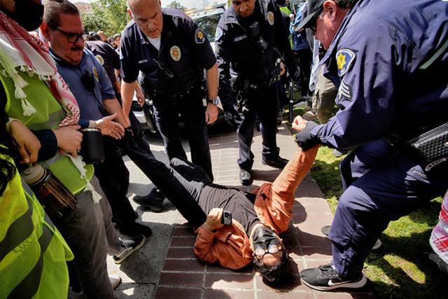 24일 미국 서부 명문 남가주대(USC)에서 친팔레스타인 시위에 나선 한 남성이 경찰에 붙잡히고 있다. 로스앤젤레스=AP 연합뉴스