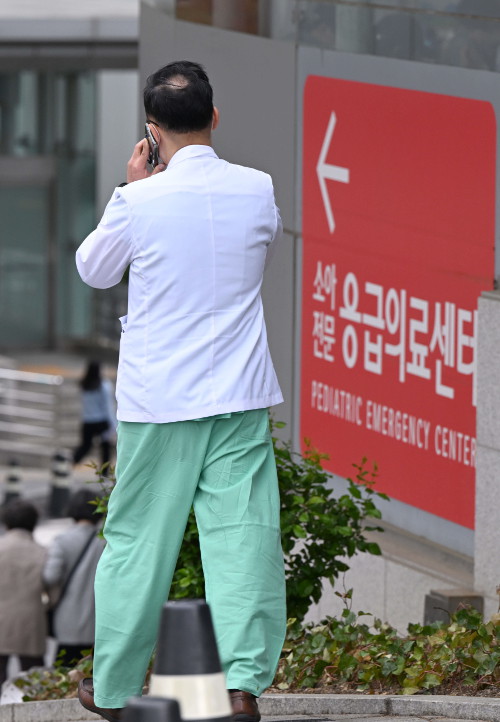 서울 종로구 서울대병원에서 24일 한 의료진이 통화를 하며 이동하고 있다. 서울대 의대·병원 교수들은 25일부터 순차적으로 사직한다고 밝혔다. 권현구 기자
