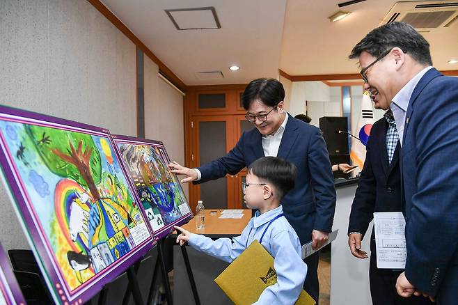 지난 23일 김포 어린이 그리기 대회 시상식에서 김병수 김포시장이 수상자 어린이에게 그림 설명을 듣고 있다. /김포시