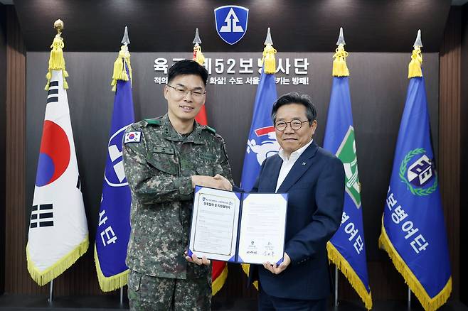 김헌동 SH공사 사장(오른쪽)과 이우헌 육군 제52보병사단장이 업무협약 체결 후 협약서를 들어보이고 있다. /SH