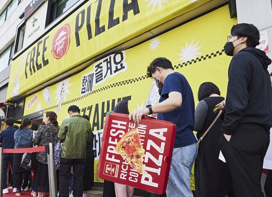지난 18일 피자헛 대치점에서 개최한 ‘FREE PIZZA’ 프로모션에 참여하기 위해 고객들이 줄을 서 있다. 사진 한국피자헛
