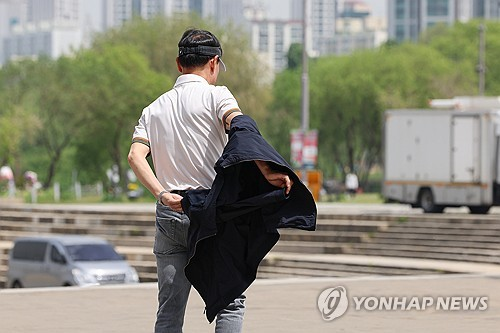 전국 대부분 지역의 낮 기온이 25도 이상으로 올라간 26일 서울 서초구 반포한강공원을 찾은 시민이 겉옷을 벗고 있다.  [사진 출처 = 연합뉴스]