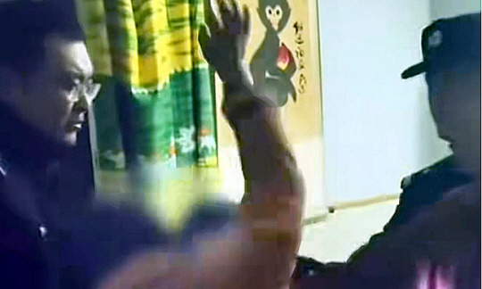 경찰들이 보는 앞에서 아들을 무차별 폭행하고 있는 엄마. SCMP 보도화면 캡처