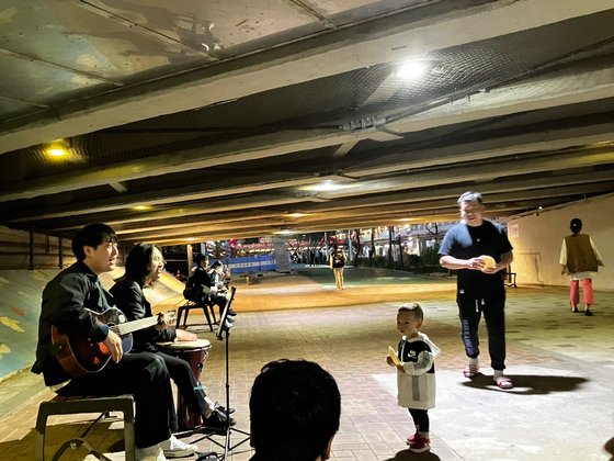 지난 21일 서울 관악구 봉림교 아래에서 '다리 밑 프로젝트'의 기타와 젬베 연주가 시작되자 한 어린 아이가 홀린듯 멈춰 서 음악을 즐기고 있다. '다리 밑 프로젝트' 제공.