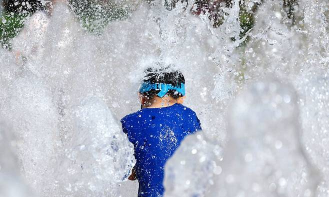 서울 중구 서울광장 분수대에서 한 아이가 물놀이를 하며 더위를 날리고 있다. 뉴시스